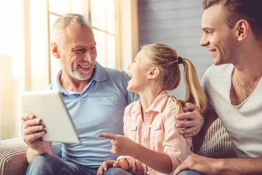 Haus-Familie-Wohnen-Serie-12-6 Opa, Vater und Tochter sitzen glücklich mit Tablet auf der Couch.