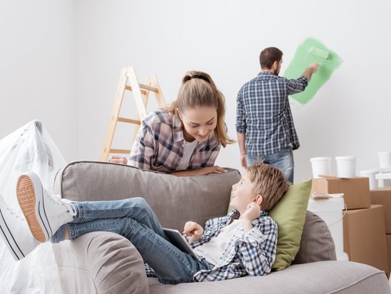 Fröhliche Familie während ihrem Umzug in dem neuen Haus